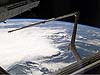 A line of thunderstorms form the backdrop for this view of Discovery's RMS robotic arm